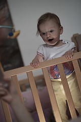 Image showing cute little one year old baby and making first steps in bed