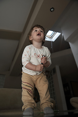 Image showing Adorable cute beautiful little baby girl playing with toys at home