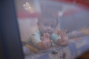 Image showing cute little baby playing in mobile bed