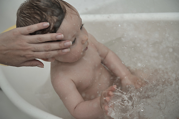 Image showing cute little baby girl taking a bath