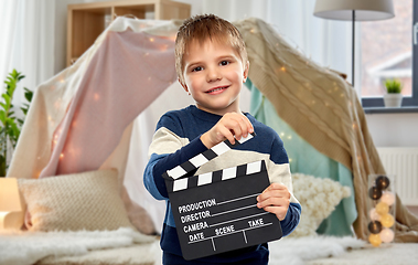 Image showing happy little boy with clapperboard at home