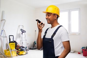 Image showing happy indian builder recording voice on smartphone