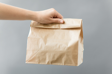 Image showing hand holding takeaway food in paper bag with lunch