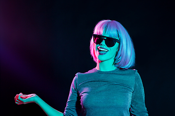 Image showing happy woman in pink wig and sunglasses dancing