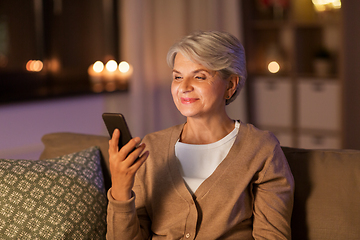 Image showing happy senior woman with smartphone at home