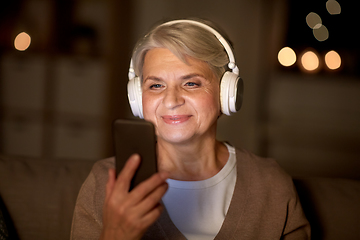 Image showing senior woman in headphones listening to music