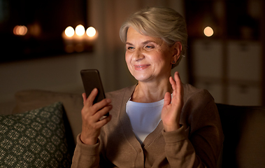 Image showing happy old woman with smartphone having video call