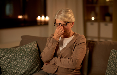 Image showing tired senior woman in glasses at home at night