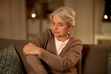 Image showing senior woman suffering from pain in hand at home