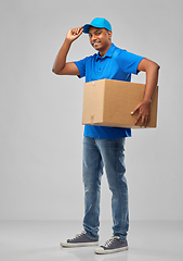 Image showing happy indian delivery man with parcel box in blue