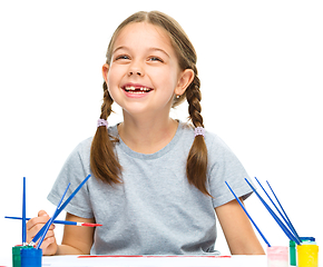 Image showing Little girl is painting with gouache