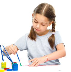 Image showing Little girl is painting with gouache