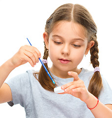 Image showing Little girl is painting with gouache