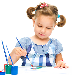 Image showing Little girl is painting with gouache