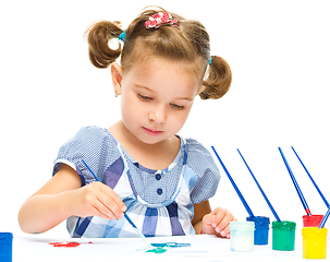 Image showing Little girl is painting with gouache