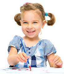 Image showing Little girl is painting with gouache