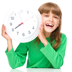 Image showing Little girl is holding big clock