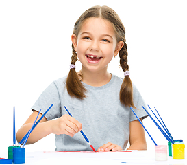 Image showing Little girl is painting with gouache