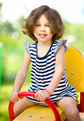 Image showing Young happy girl is swinging in playground