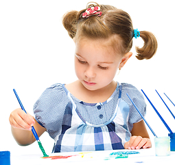 Image showing Little girl is painting with gouache