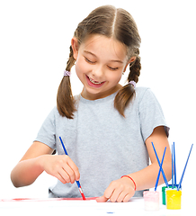 Image showing Little girl is painting with gouache