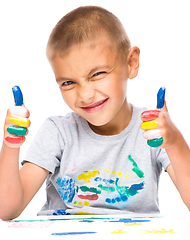 Image showing Portrait of a cute boy playing with paints