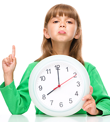 Image showing Little girl is holding big clock