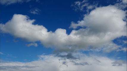 Image showing Time lapse Fluffy clouds float across the blue sky. UltraHD stock footage