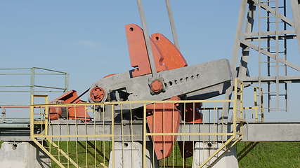 Image showing Operating oil and gas well in oil field, profiled against the blue sky