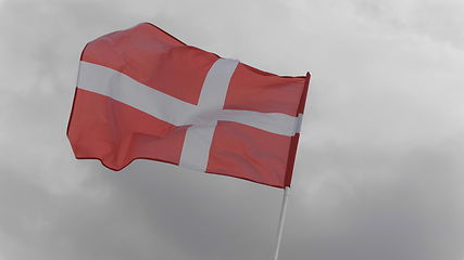 Image showing Denmark flag on the flagpole waving in the wind against a blue sky with clouds. Slow motion