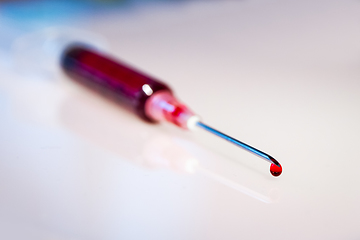 Image showing Syringe needle with blood macro view