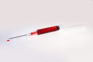 Image showing Syringe with blood on white background