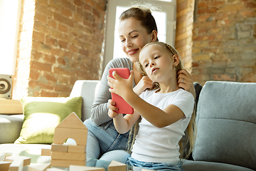 Image showing Teacher and little girl, or mom and daughter. Homeschooling concept