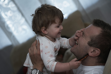 Image showing father holding and kissing little baby