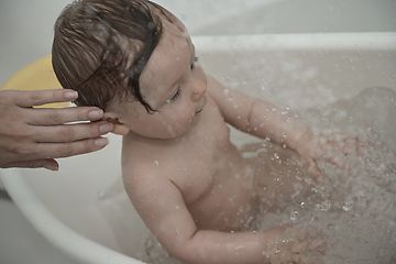 Image showing cute little baby girl taking a bath