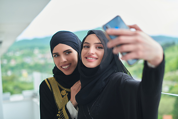 Image showing Portrait of young muslim women taking selfie on the balcony