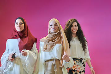 Image showing Young muslim women posing on pink background
