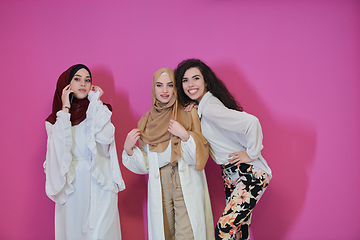 Image showing Young muslim women posing on pink background