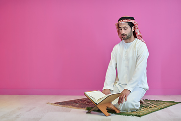 Image showing Young muslim man reading Quran during Ramadan