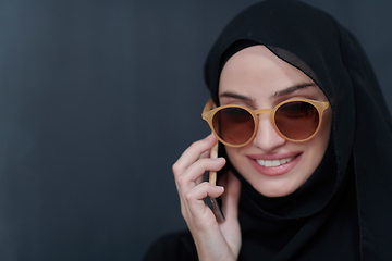 Image showing Young muslim businesswoman in traditional clothes or abaya using smartphone