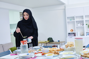 Image showing Young muslim woman serving food for iftar during Ramadan