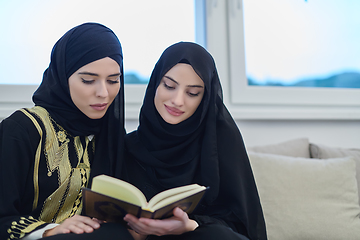 Image showing Portrait of young muslim women reading Quran in modern home.