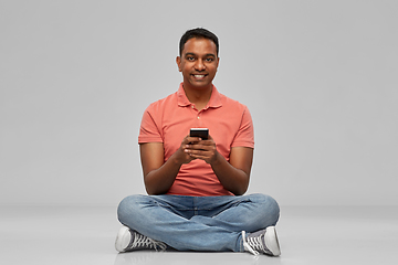 Image showing happy indian man using smartphone