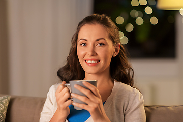 Image showing happy woman drinking tea or coffee at home