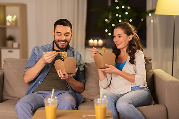 Image showing happy couple eating takeaway noodles at home