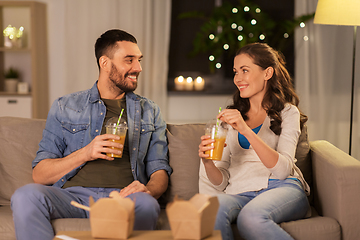 Image showing happy couple drinking takeaway juice at home