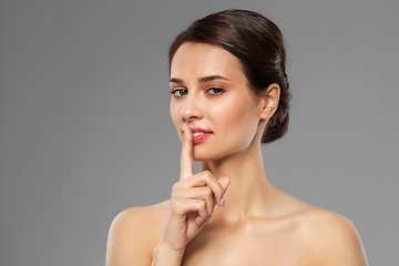 Image showing beautiful young woman holding finger on lips