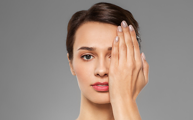 Image showing young woman closing one eye with hand