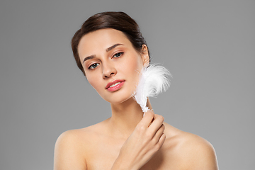Image showing beautiful woman with feather touching her face