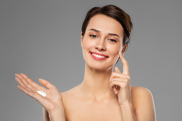 Image showing young woman with moisturizing cream on finger